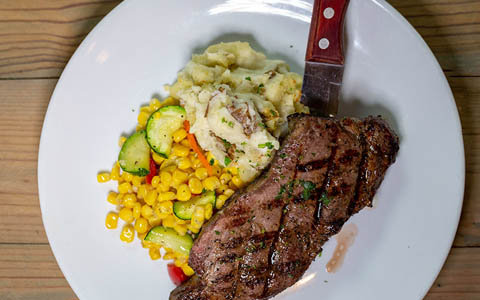 Steak with mashed potatoes and vegetables, top view